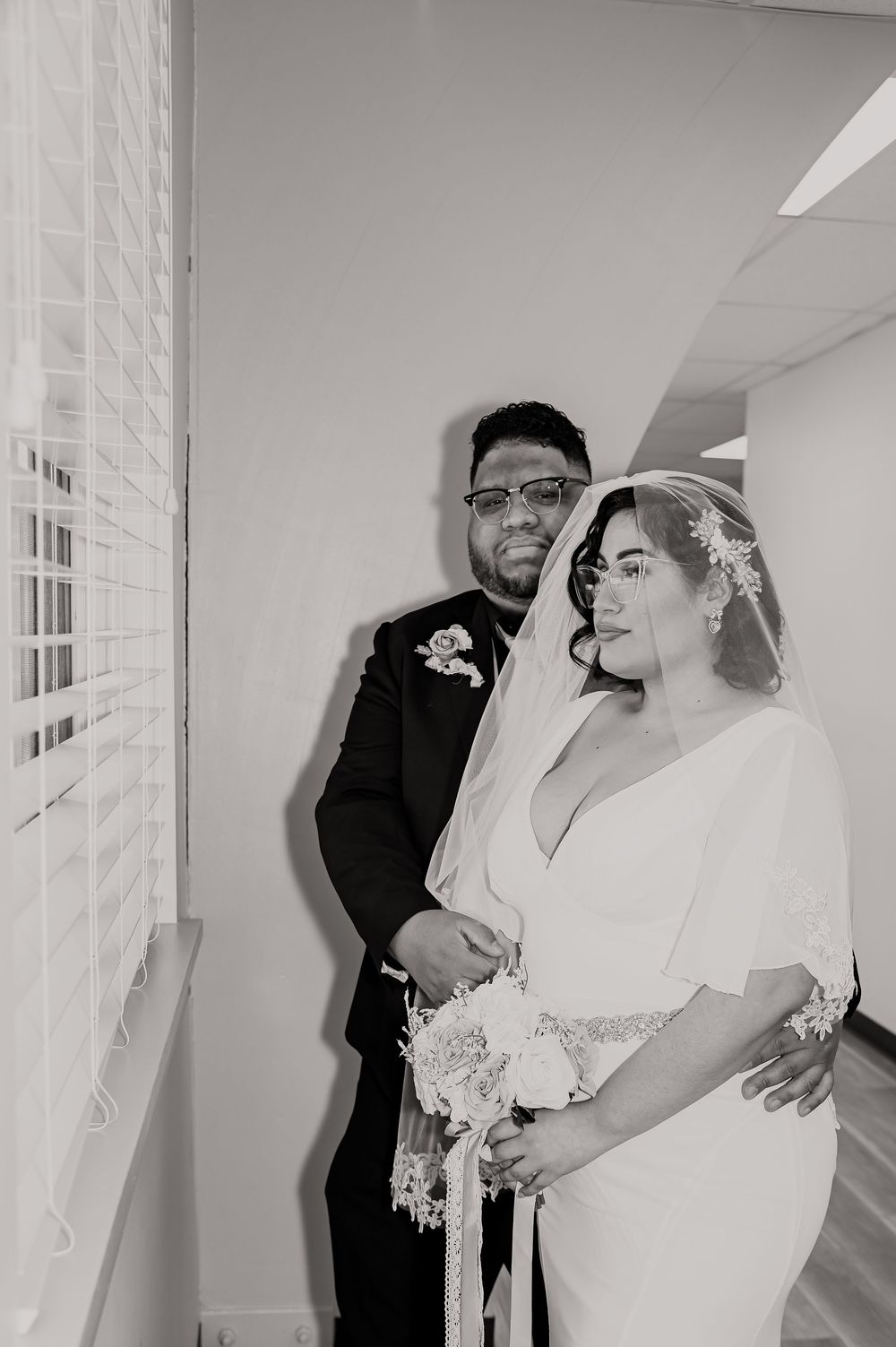 A touching first look moment between a bride and groom in a hallway before their wedding ceremony.