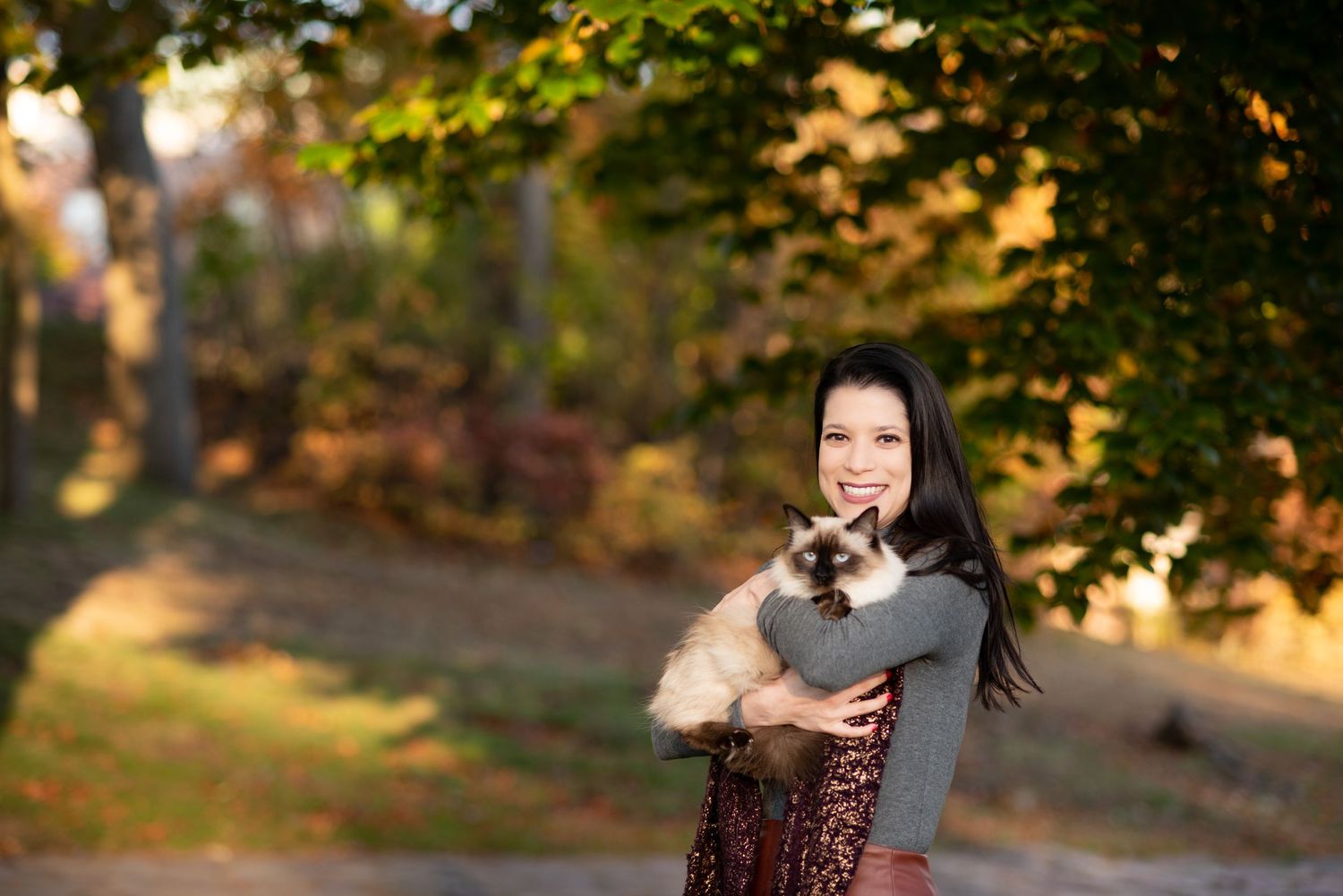 Women’s professional portraits & pet photos. Fall foliage autumn pictures woman with cat in Medford, MA with Leah Ramuglia Photography.