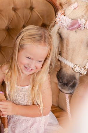 Sweet moment between a child and decorated pony at a special event.