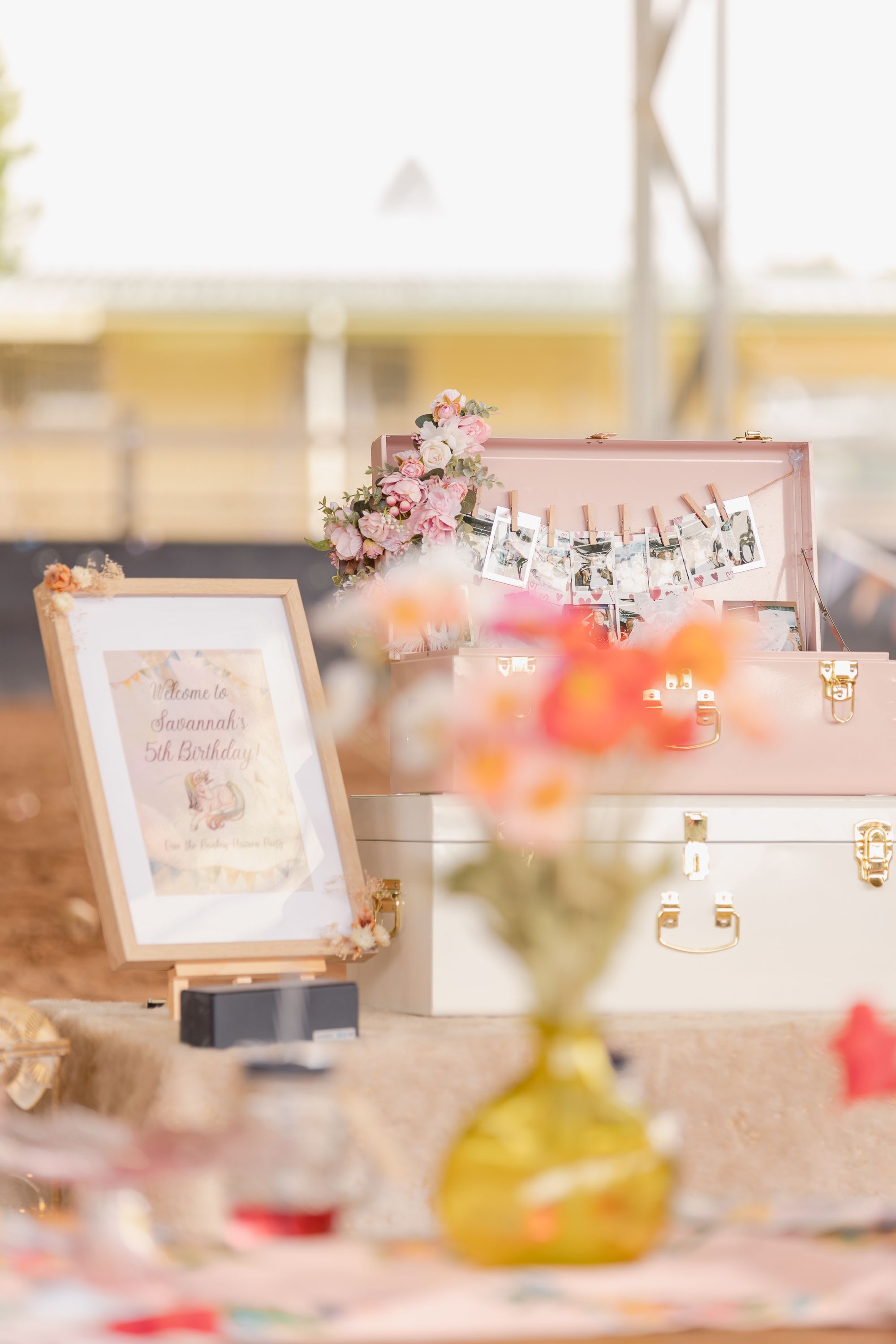 Soft focus party decorations with pink floral frames and signs on display.