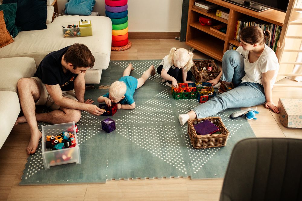 Children playing with colorful toys on a foam play mat floor.