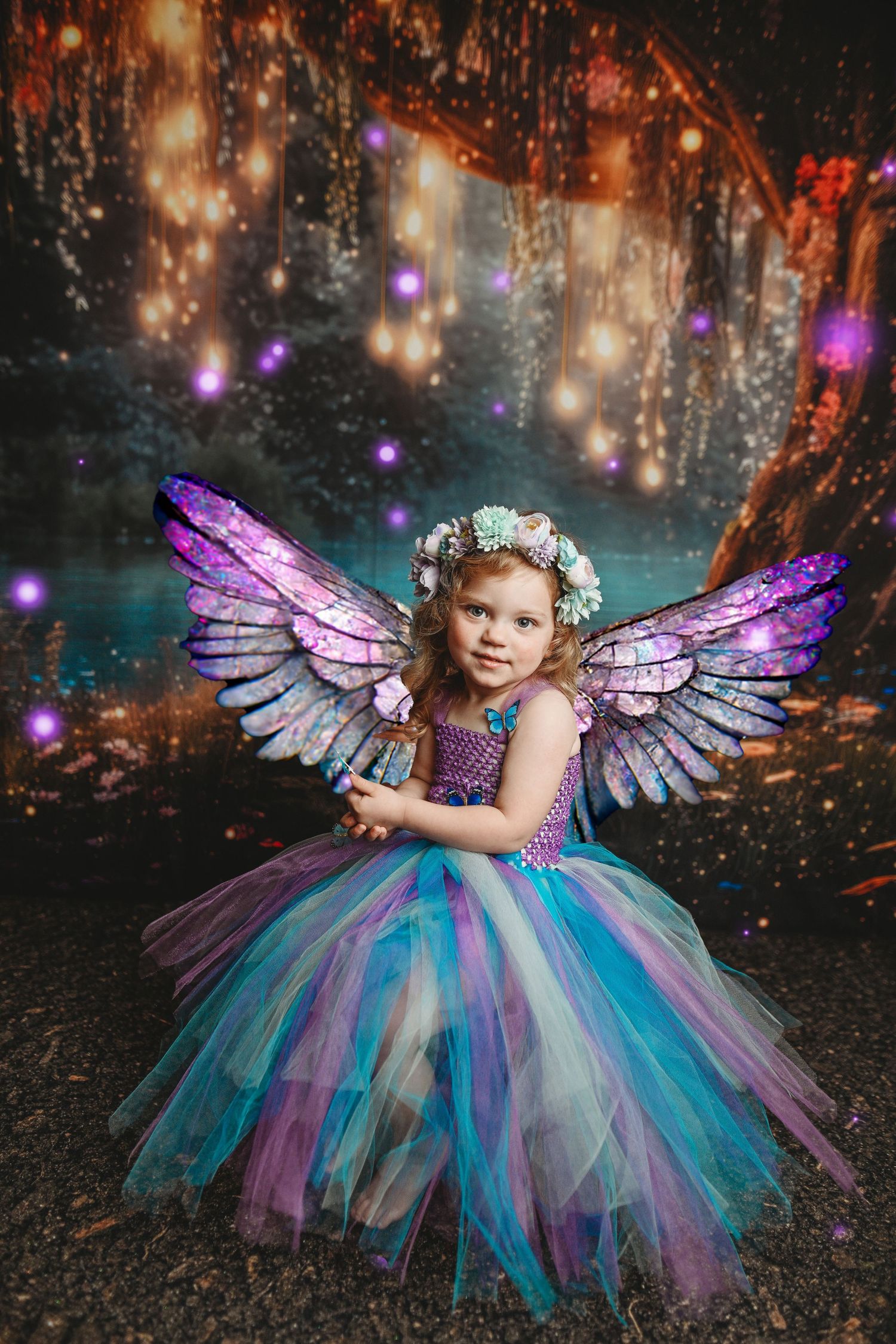 Whimsical portrait featuring sparkly purple fairy wings and colorful tulle dress amid glowing lights.