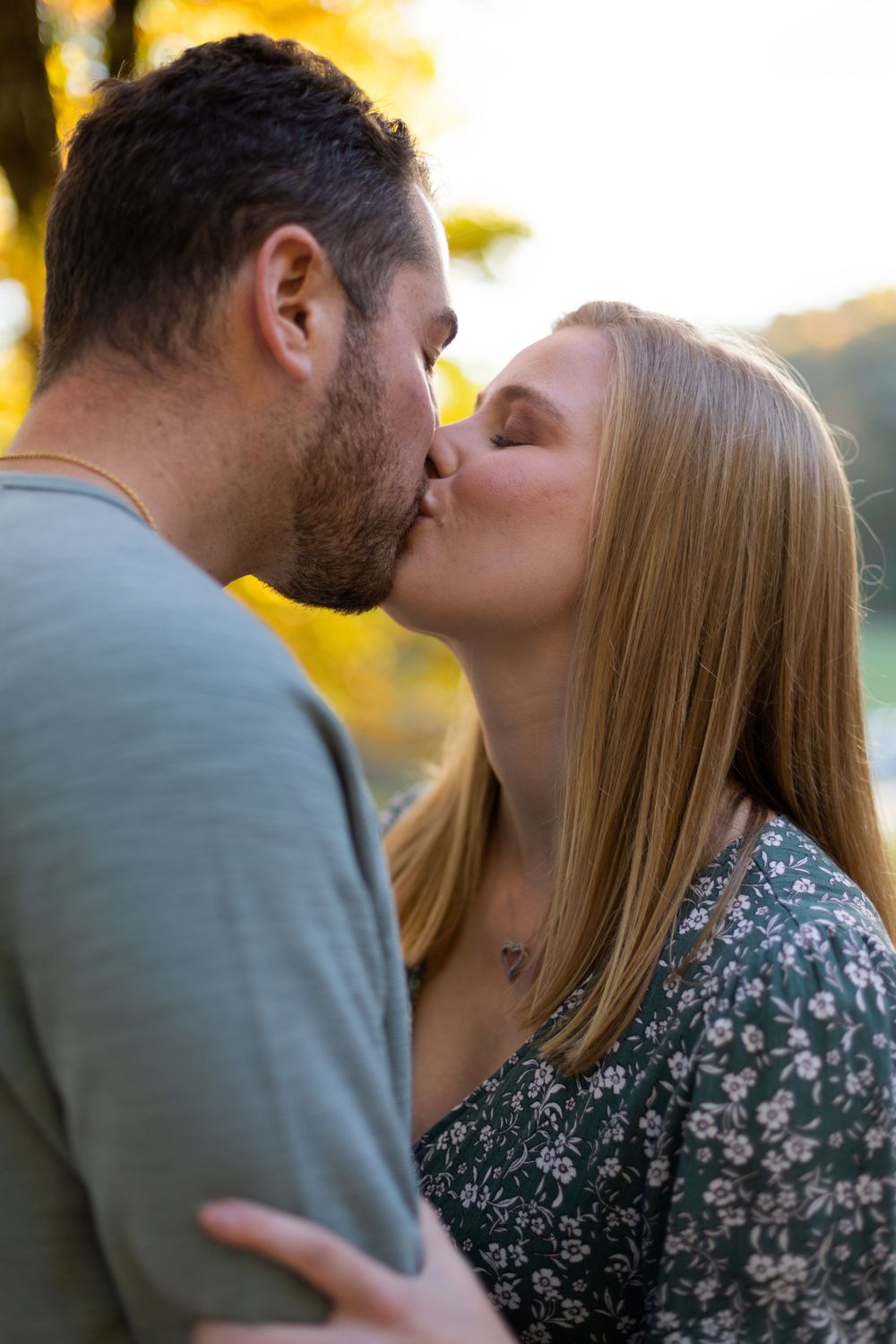 Romantic sunset kiss with golden light in background.