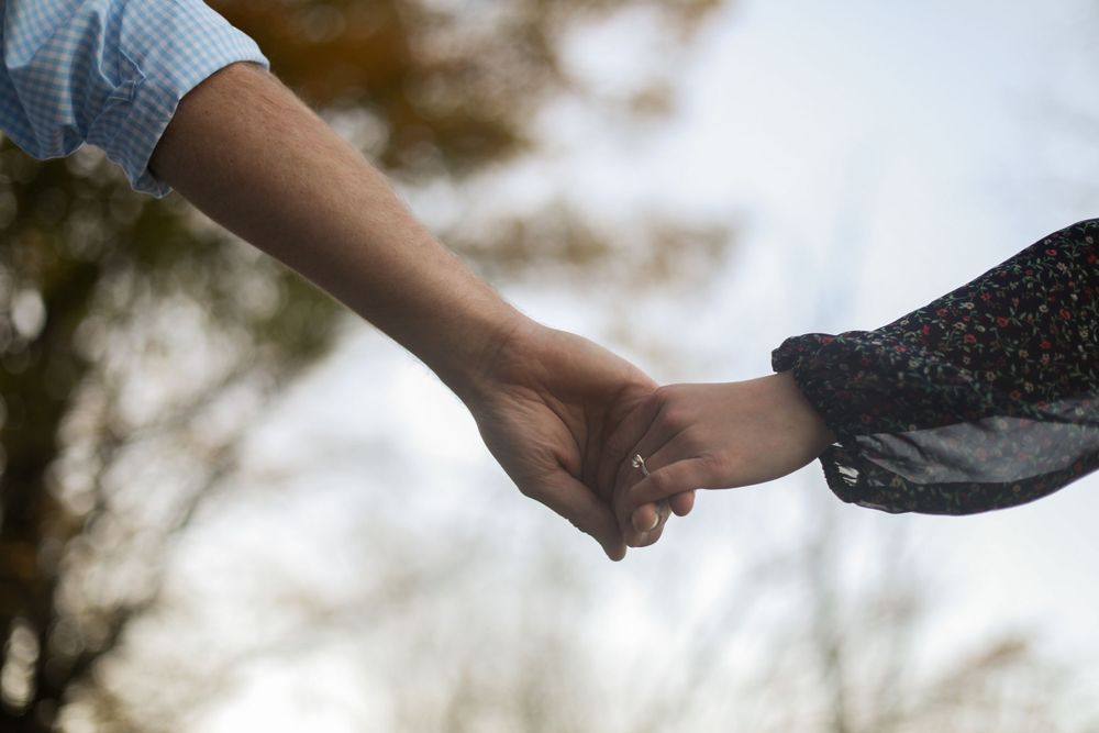Series of hands exchanging a ring during a romantic proposal.