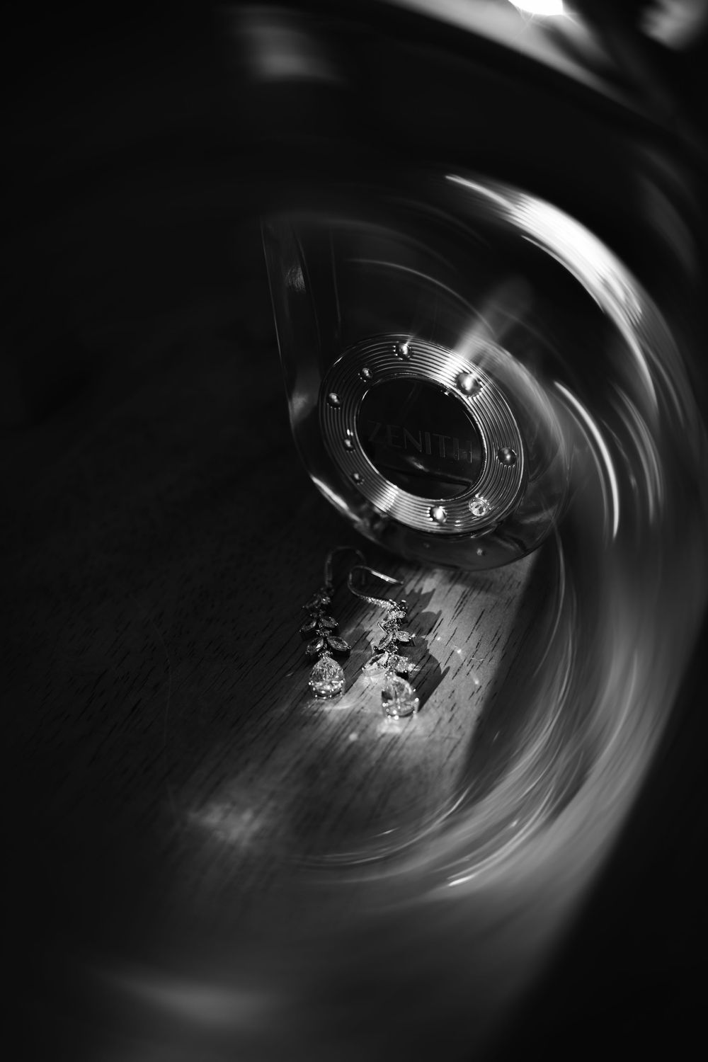 Black and white macro photo of a spinning metal drum interior with a central bolt cap and scattered debris.