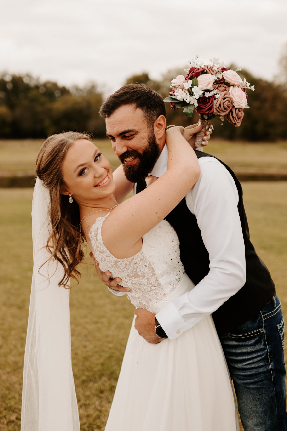 Couple shares intimate dancing moment in field during rustic countryside wedding. Oklahoma Wedding Photographer