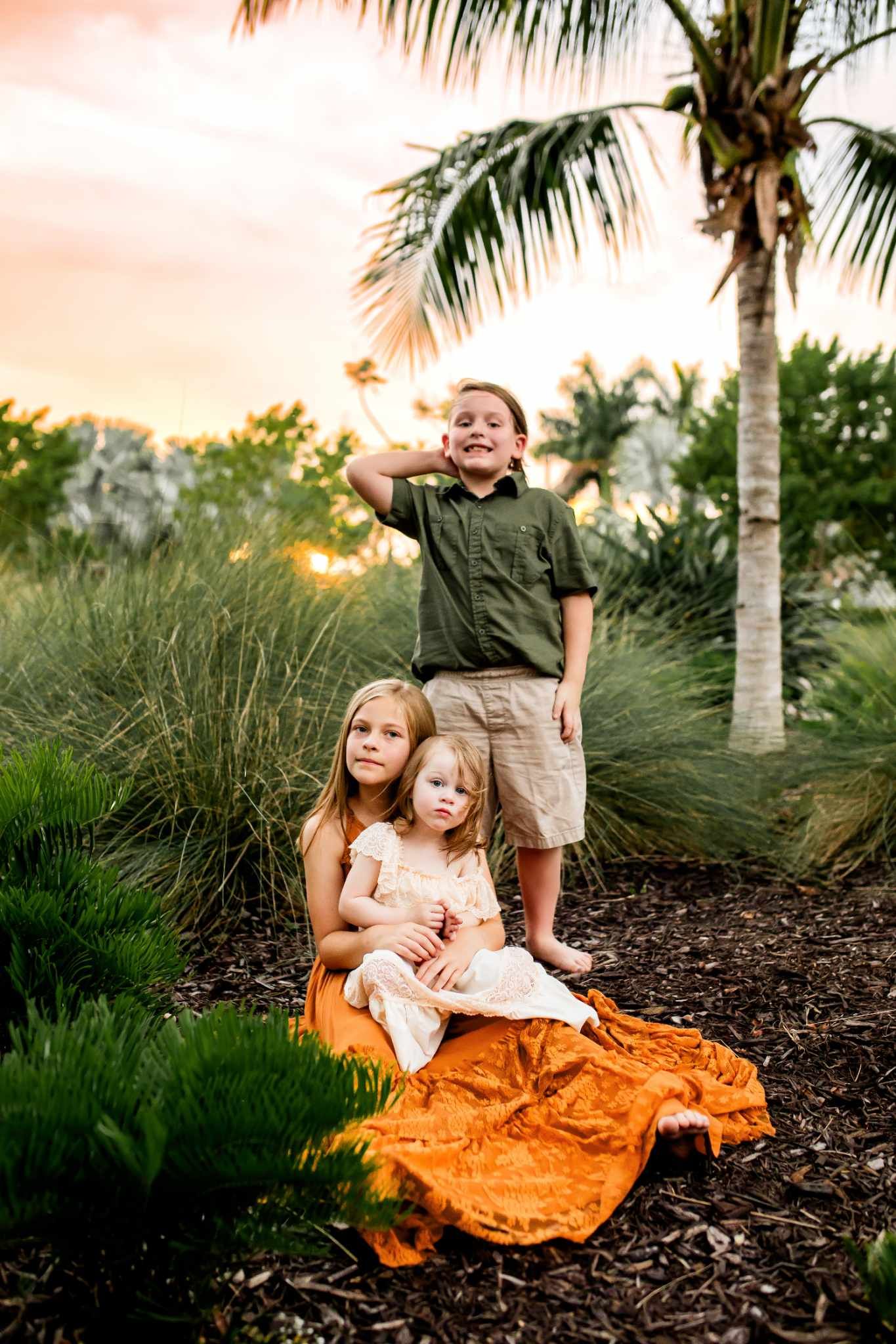 Children playing together on landscaped grounds during golden hour.