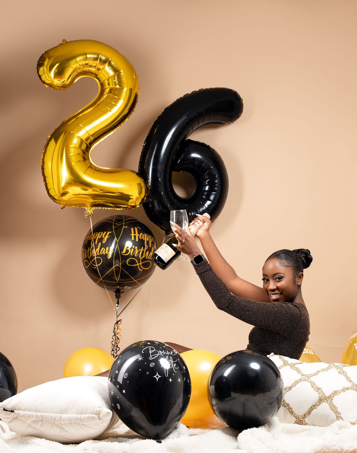 Celebratory scene with gold and black number 26 balloons and festive decorations.