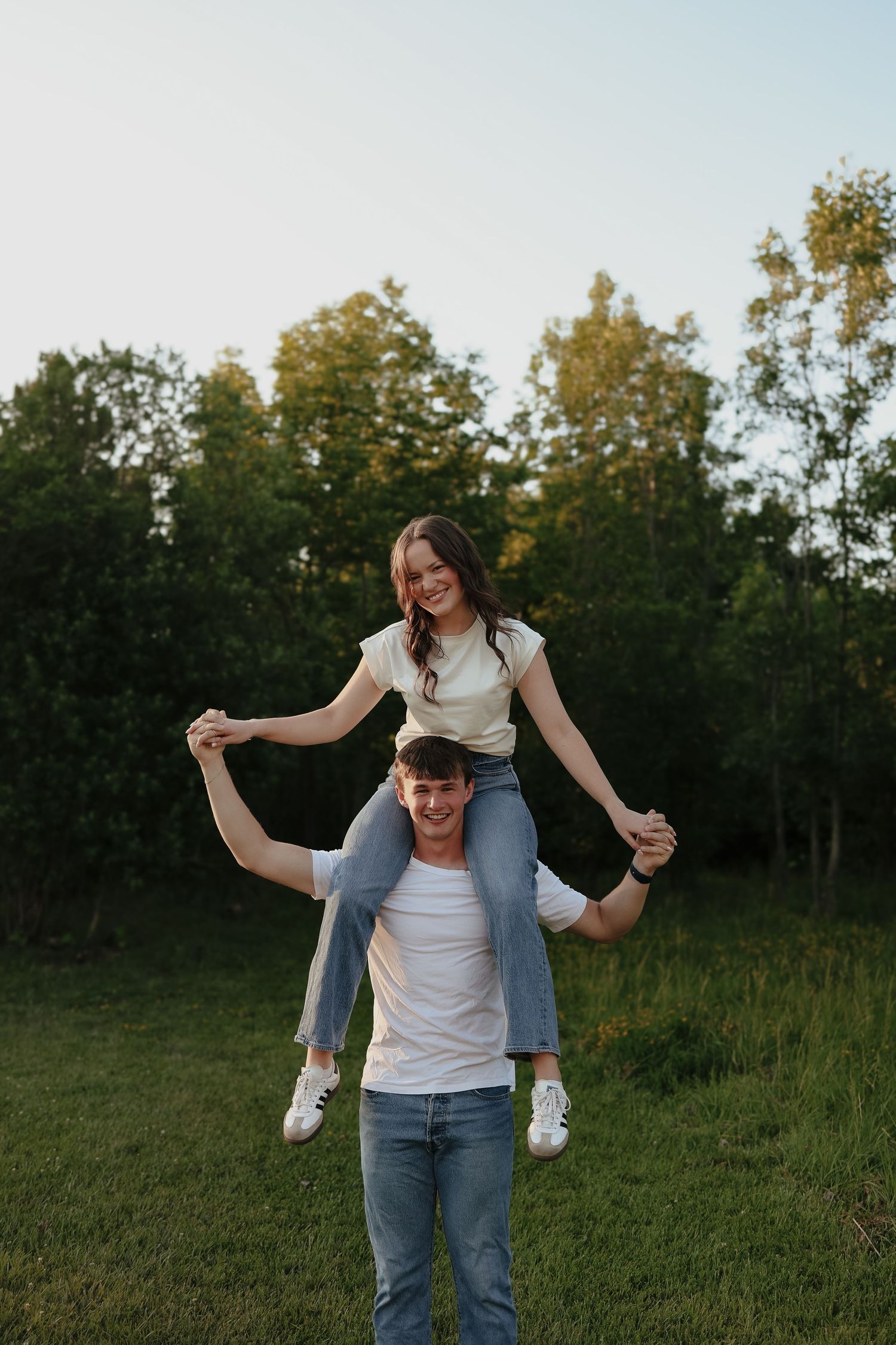 A romantic dance in a sunlit garden with lens flare through tree branches overhead.