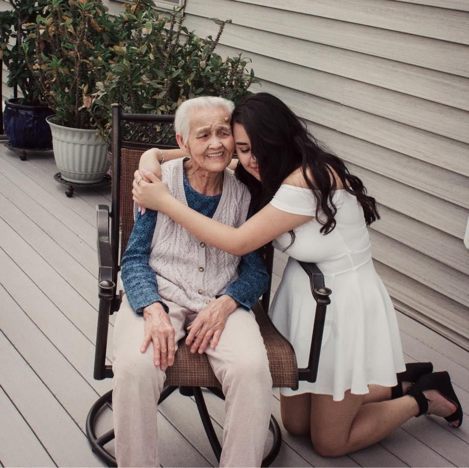 A touching moment shared between two people on a porch bench.