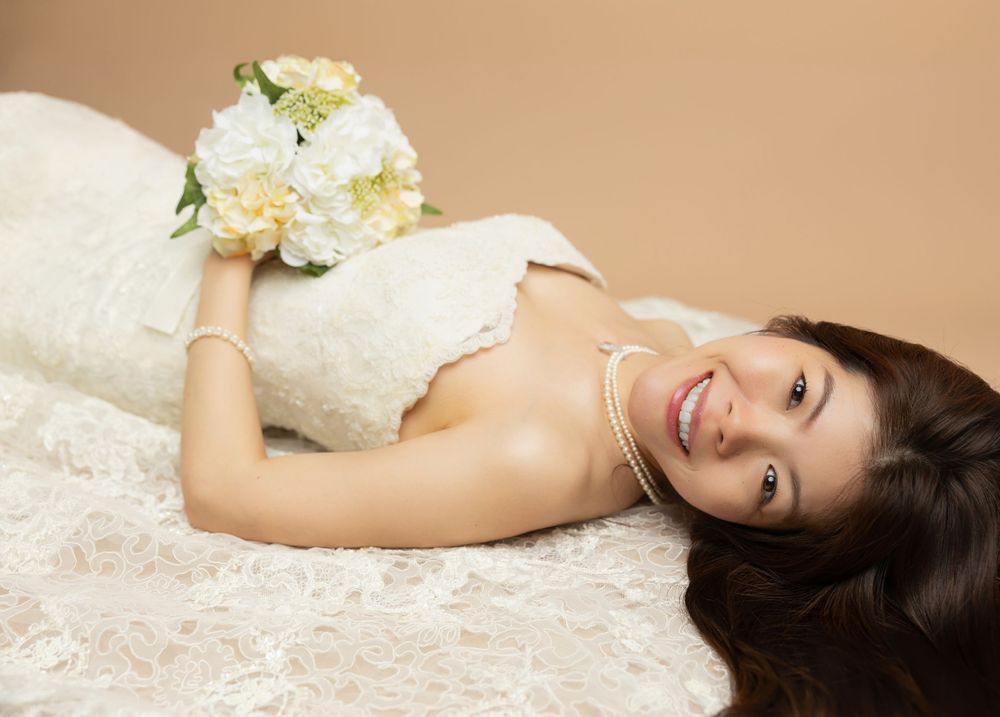 Romantic bridal portrait with soft lighting featuring white flowers and lace details.