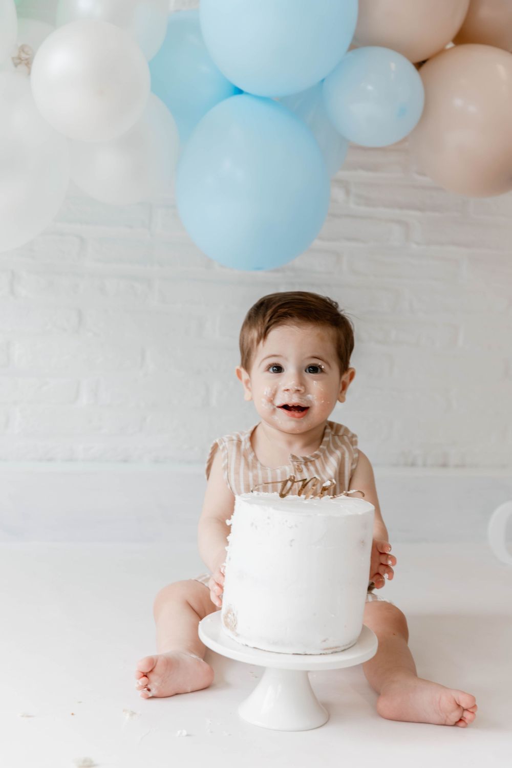 Sweet cake smash photo session with balloons showing progression from anticipation to messy enjoyment.