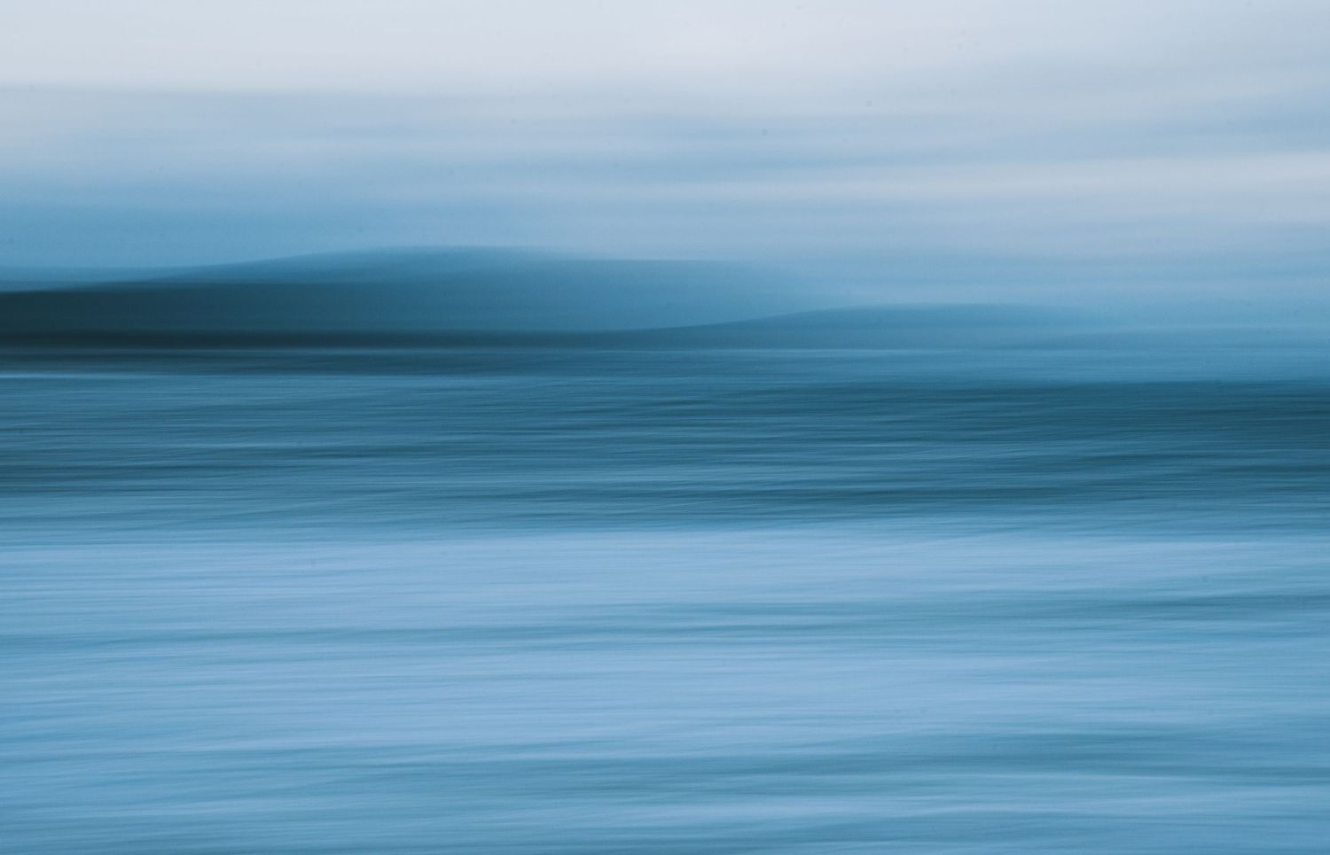 Abstract minimalist seascape with smooth blue tones blending into the horizon.