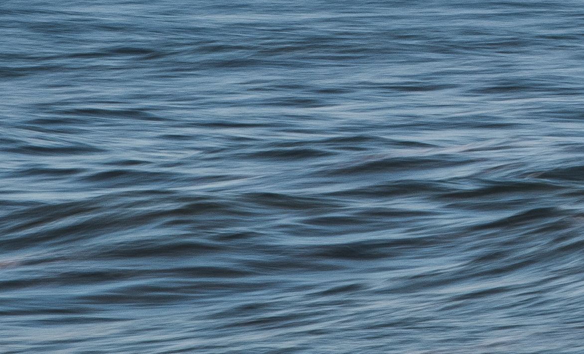 Rippling blue ocean water surface with gentle wave patterns.