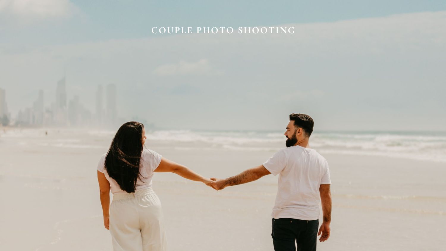 Couple holding hands while walking on beach with inspirational text overlay.