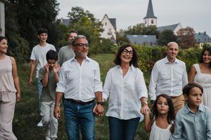 Family walking together with church steeple visible in background landscape.