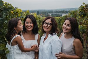 Family members share joyful moments together during outdoor portrait session with natural scenery.