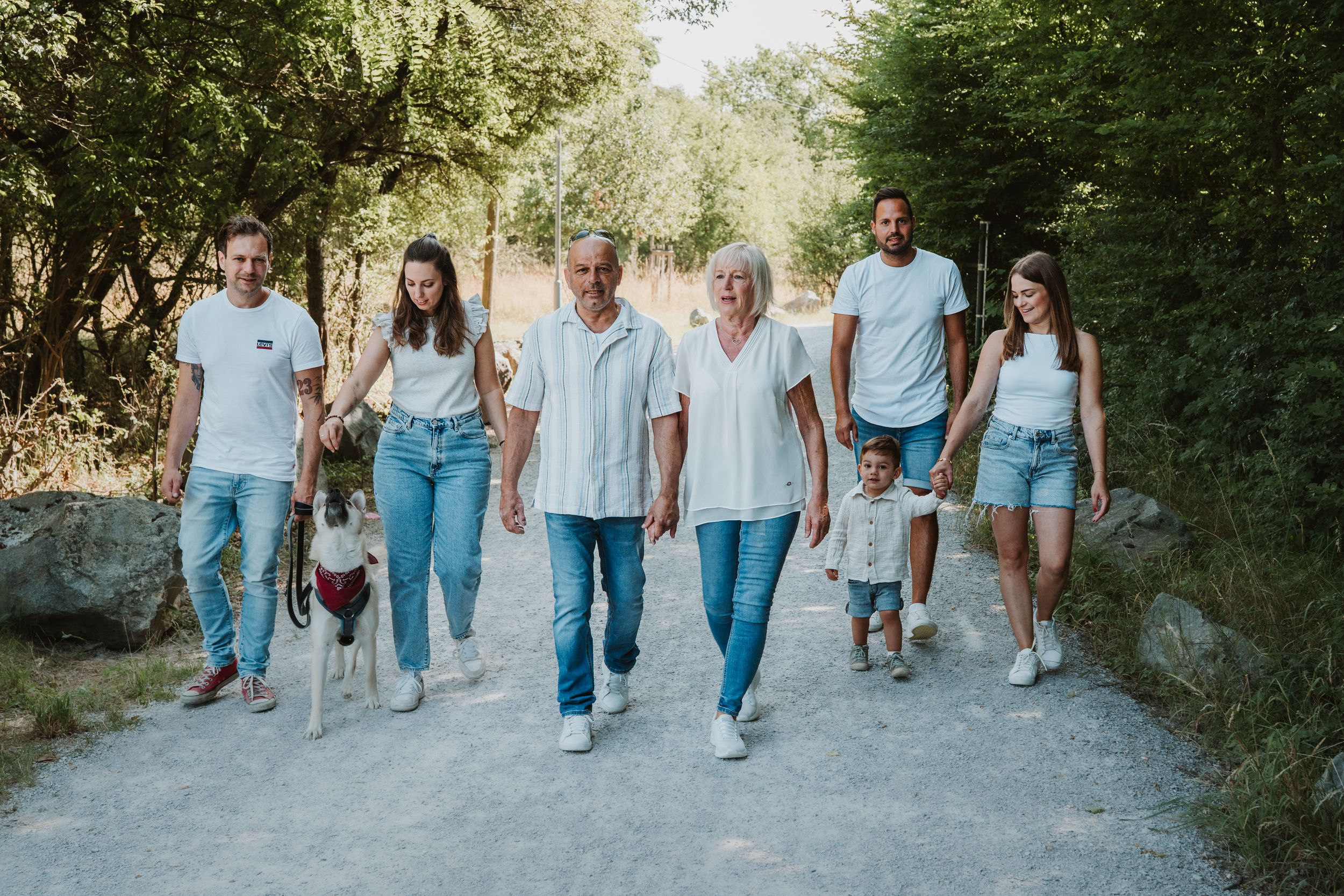Group walking together on a path wearing coordinated blue jeans and white tops.