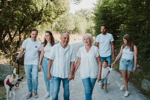 Extended family strolling together on a nature path in coordinated casual outfits.