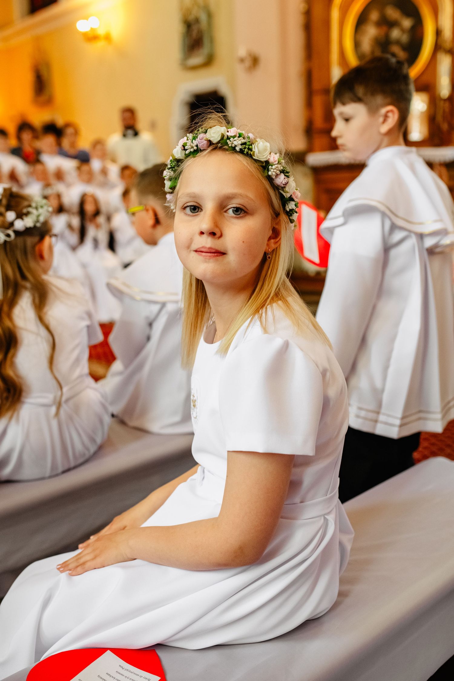 Fotograf na komunię Krasnystaw – detal stroju, świecy i dodatków.