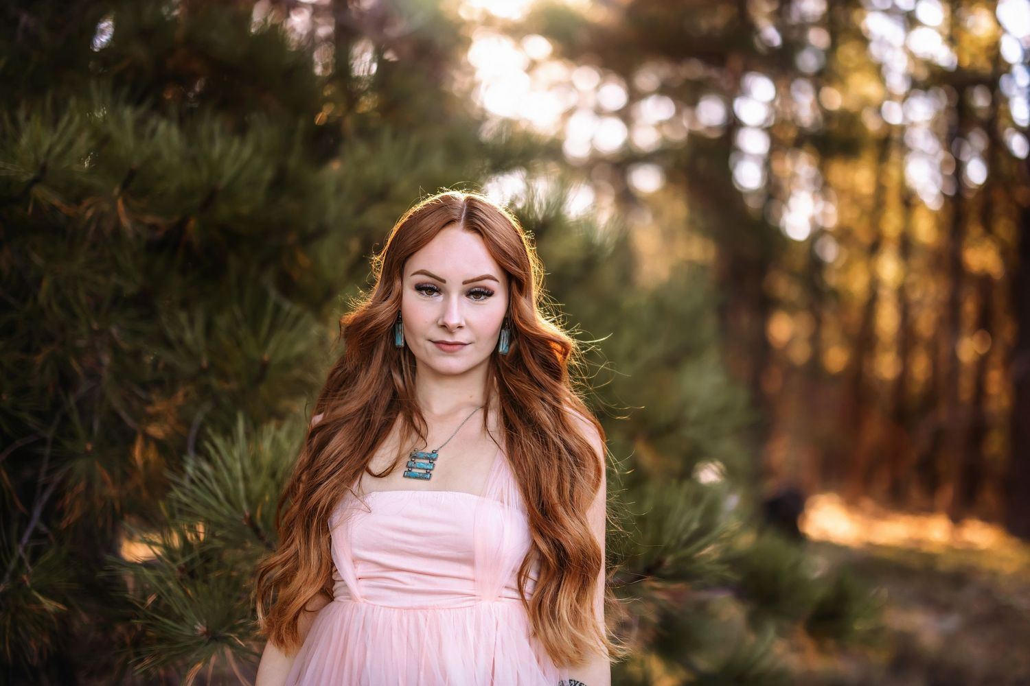 Soft natural lighting illuminates a dreamy woodland portrait with pink tones.