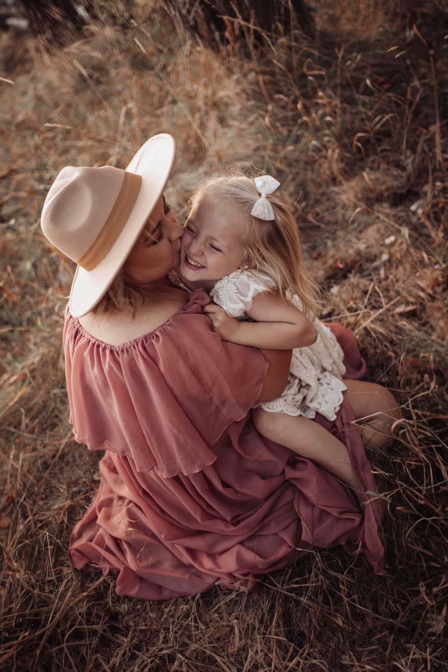 Tender family moment captured in warm tones with rustic outdoor setting.