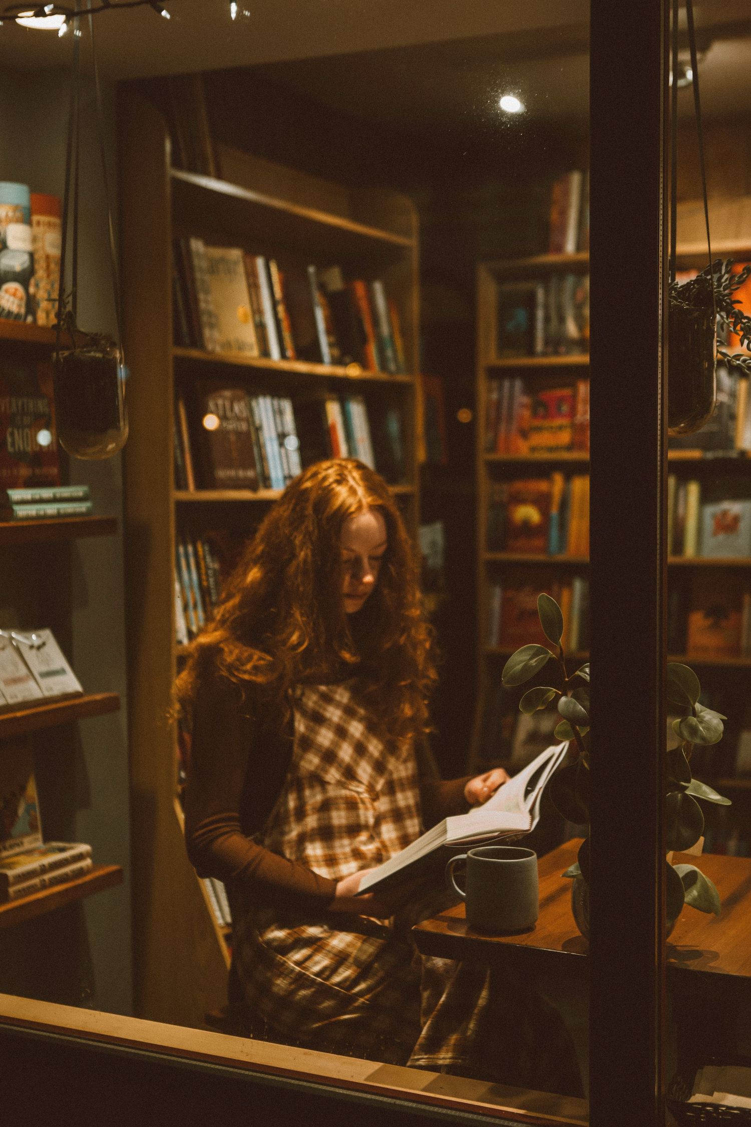 Cozy bookstore interior at night with warm lighting and wooden bookshelves.
