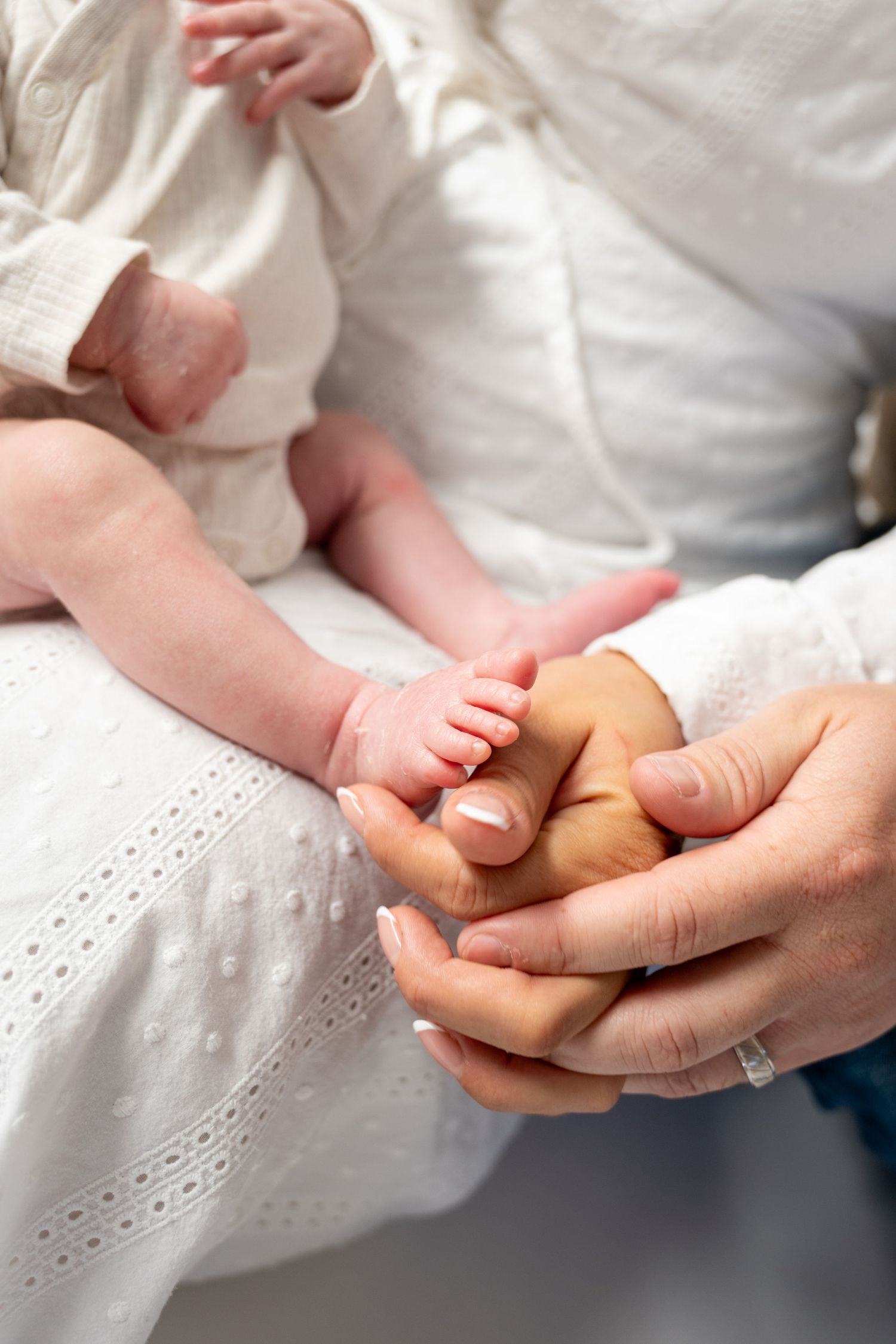 Close up of tiny newborn baby feet being gently held by adult hands.