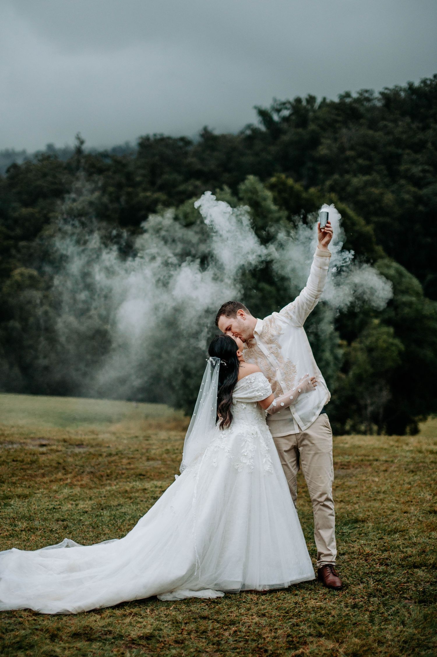 Dramatic wedding pose with smoke effects against a forest backdrop.