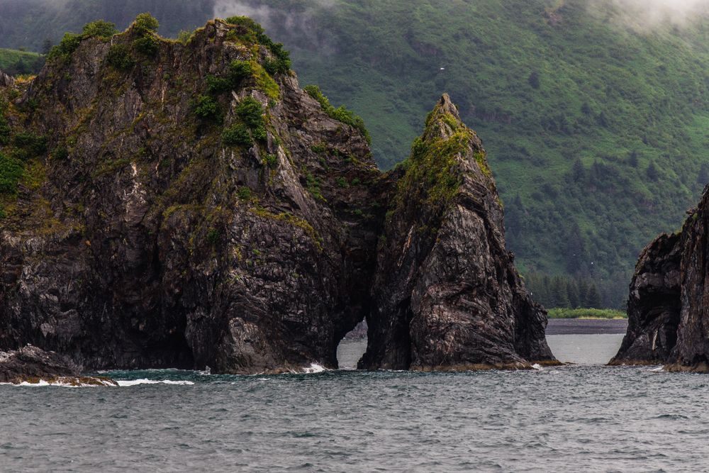 Dramatic rocky sea stacks with natural archways carved by ocean waves.
