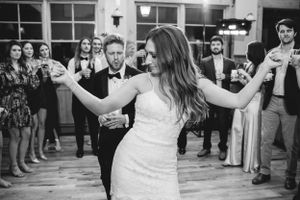 Wedding celebration showing dancing and celebration in indoor venue.