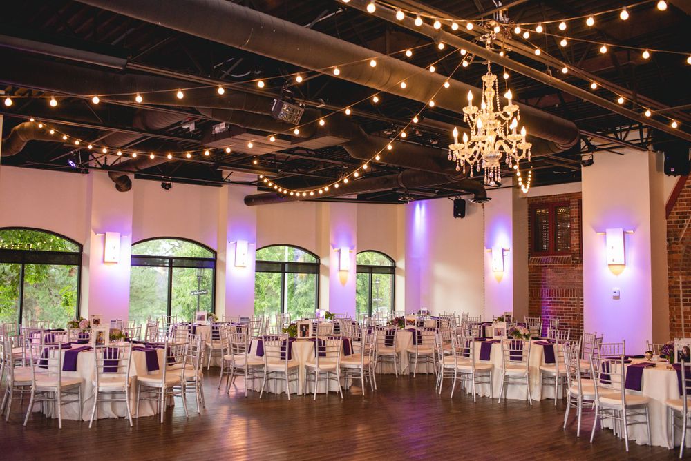 An elegant reception hall with crystal chandeliers and string lights creating a romantic atmosphere.