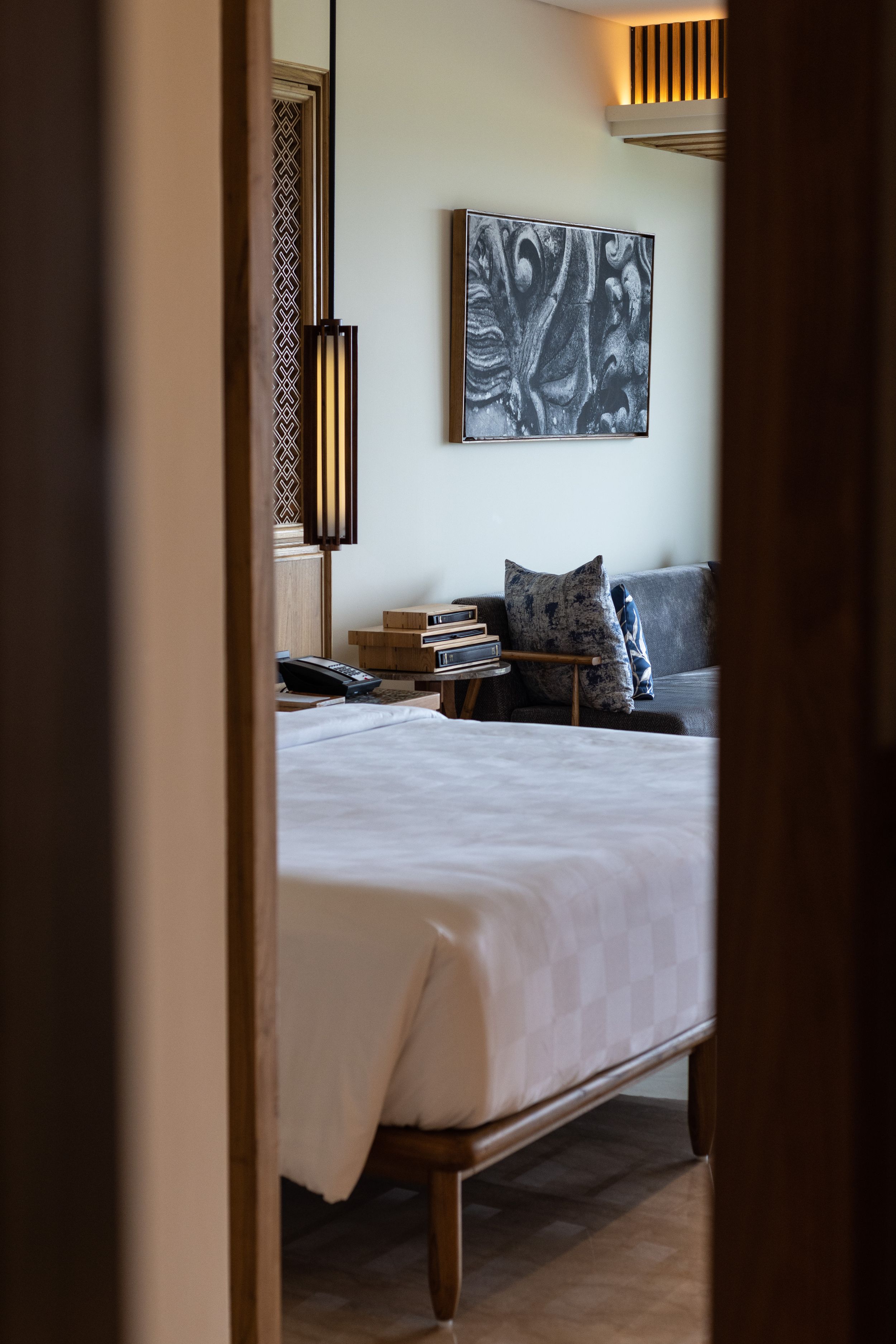 Modern hotel bedroom interior with abstract wall art and minimalist decor.