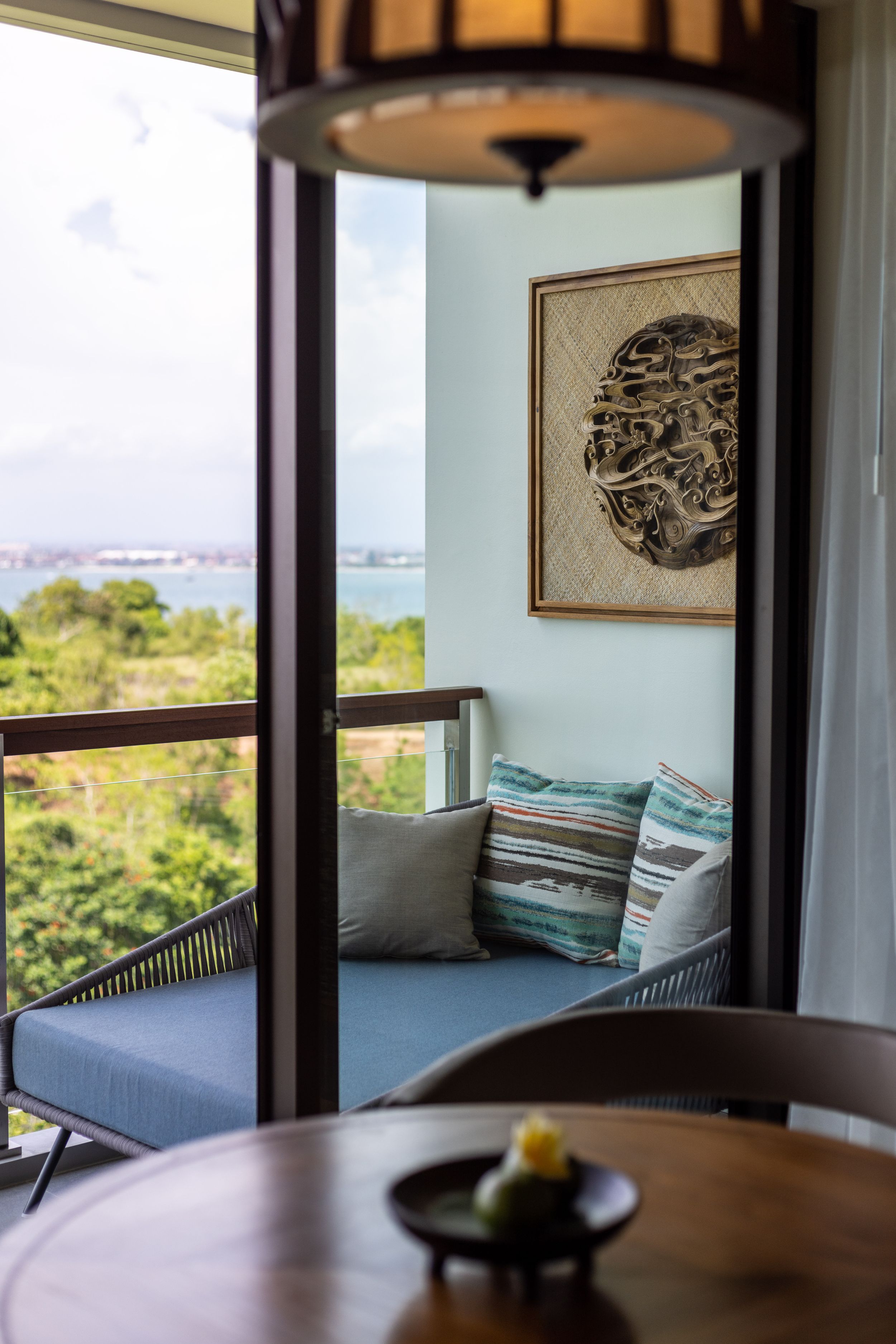 Cozy seating area with ocean view and decorative wall art in luxury hotel room.
