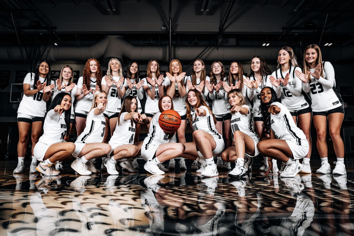 The 2023-2024 JV and Varsity women's basketball team from Woodinville High School is posing in group photo.