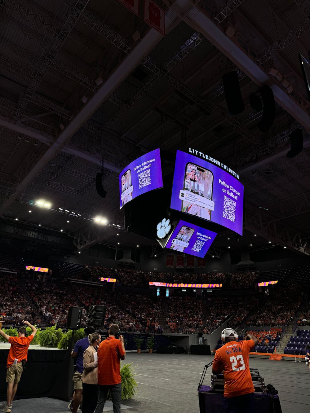 Arena scoreboard display glowing purple in a darkened stadium during an event.