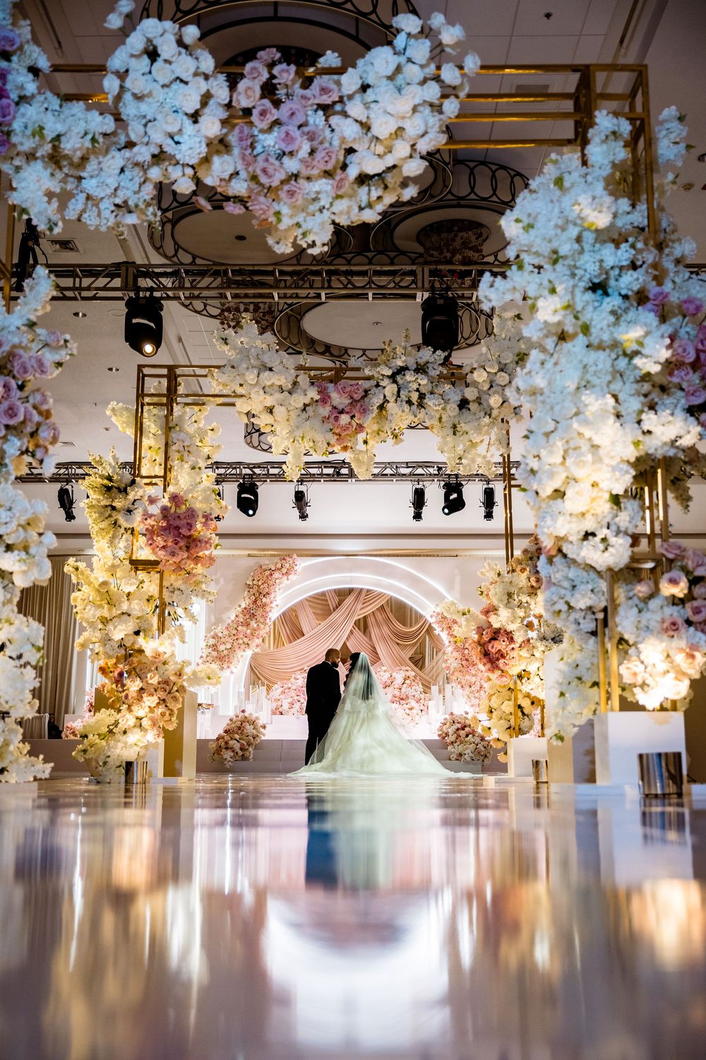 Elegant wedding venue decorated with elaborate floral arrangements and soft lighting creating a romantic atmosphere.