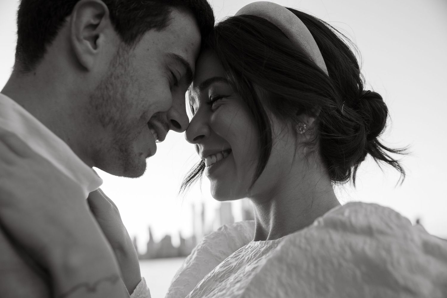 Intimate black and white portrait of a couple sharing a tender romantic moment together.