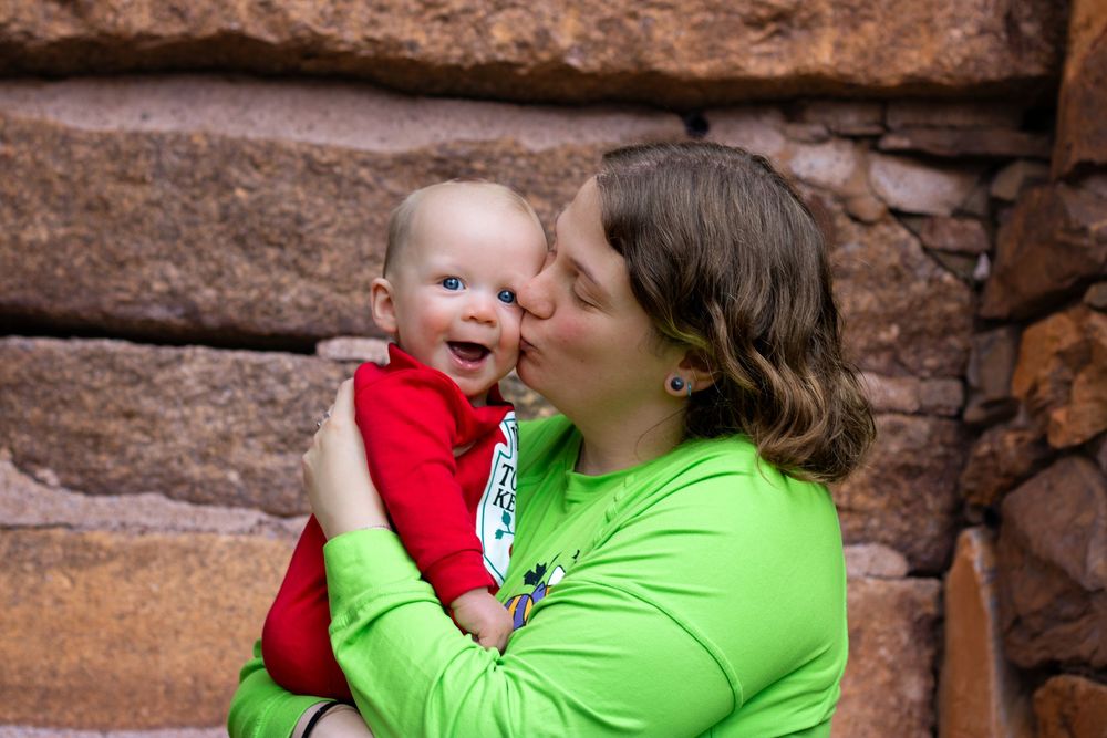 A tender moment captured against red rock formations outdoors.