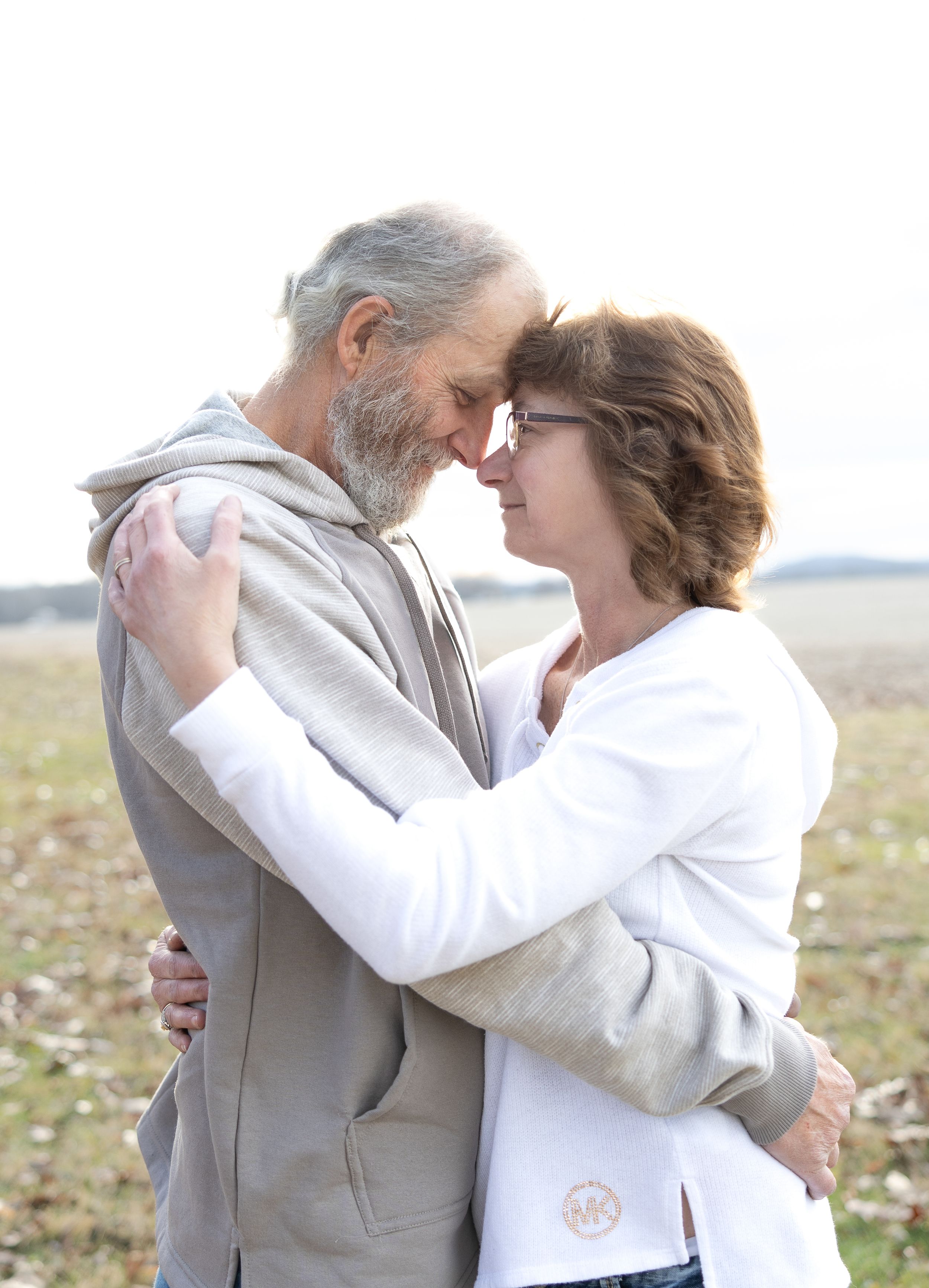 Couple holding each other in a field in Tuscarawas, Ohio.