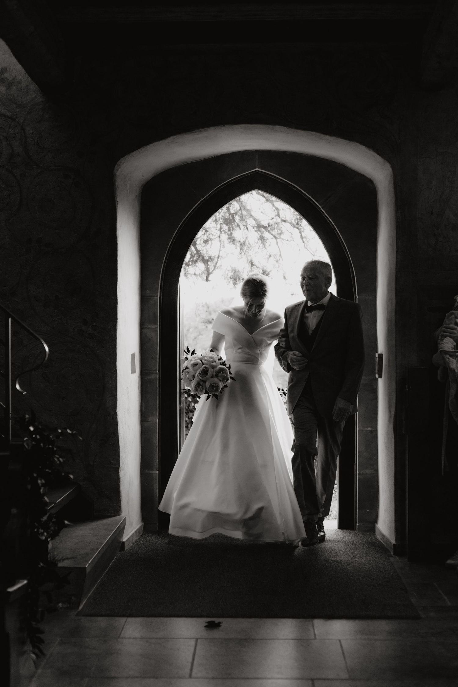 Silhouette of a couple framed in an arched doorway during their wedding ceremony.