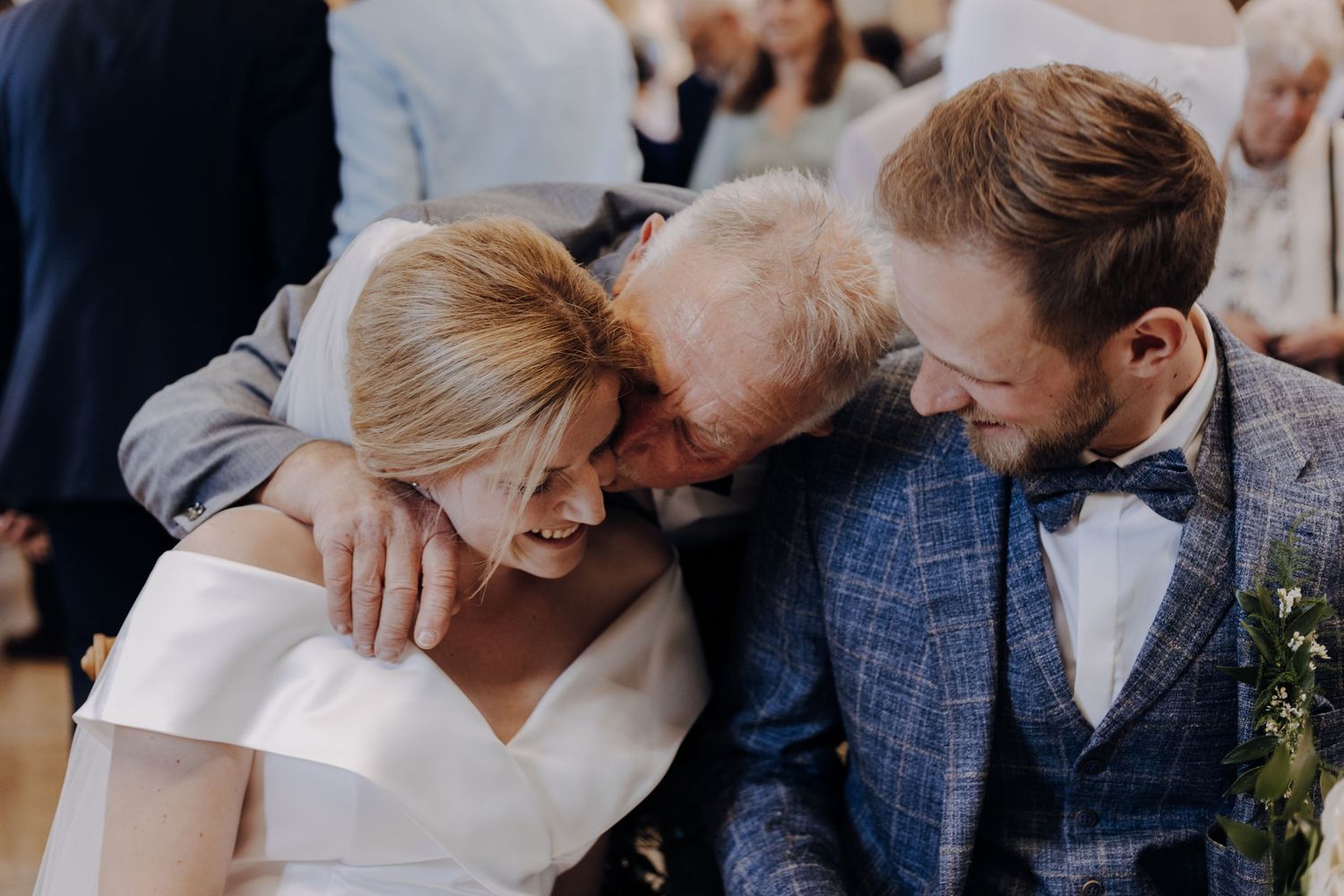 A joyful candid moment shared between a bride and groom in formal wedding attire during their celebration.
