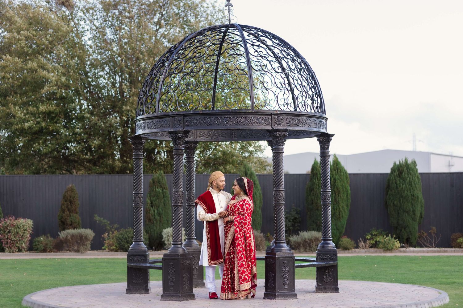 Just married newly weds smiling towards each other under the canope expressing their love captured by the camera