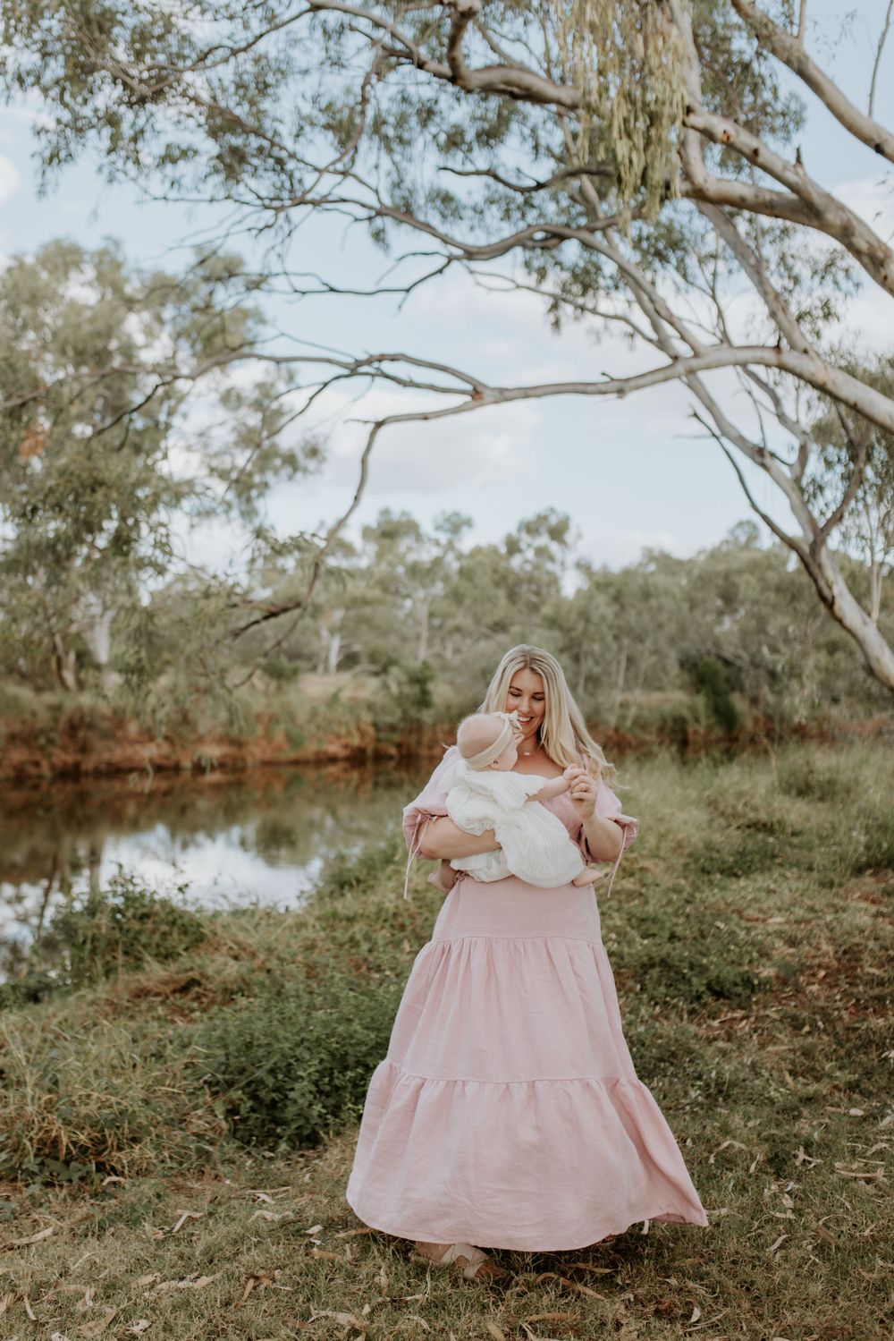 motherhood session in mount isa. mother and daughter dance in front of river