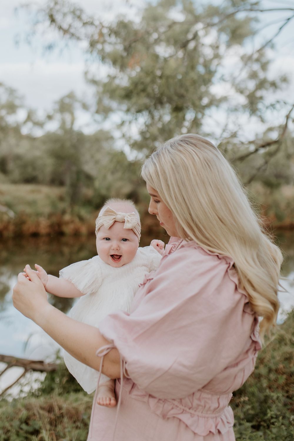 motherhood session in mount isa. mother and daughter dance in front of river