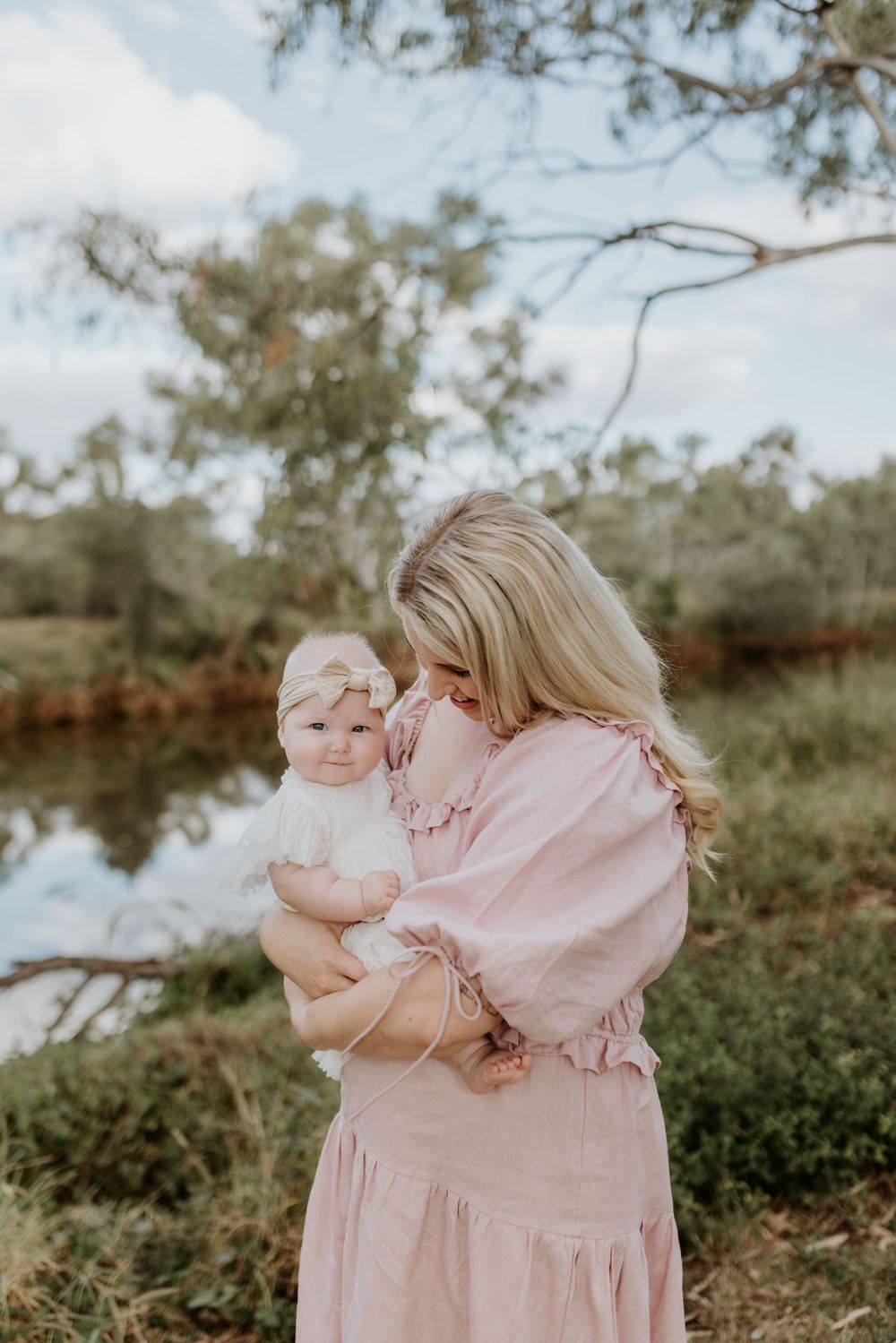 mother looking down at daughter with river in background