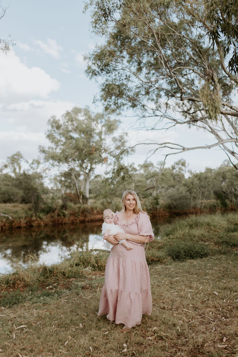 mother and daughter walking with river in background