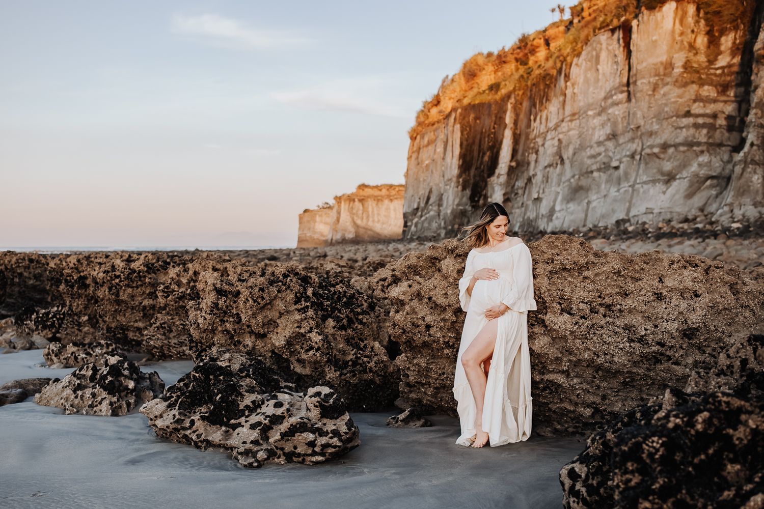 Maternity portrait of expectant mother during golden-hour at beach Westport NZ