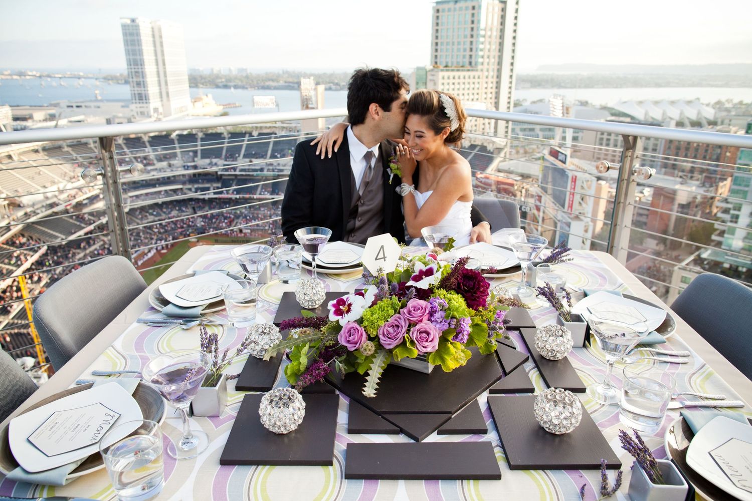 bride and groom sitting at table with petco park behind them