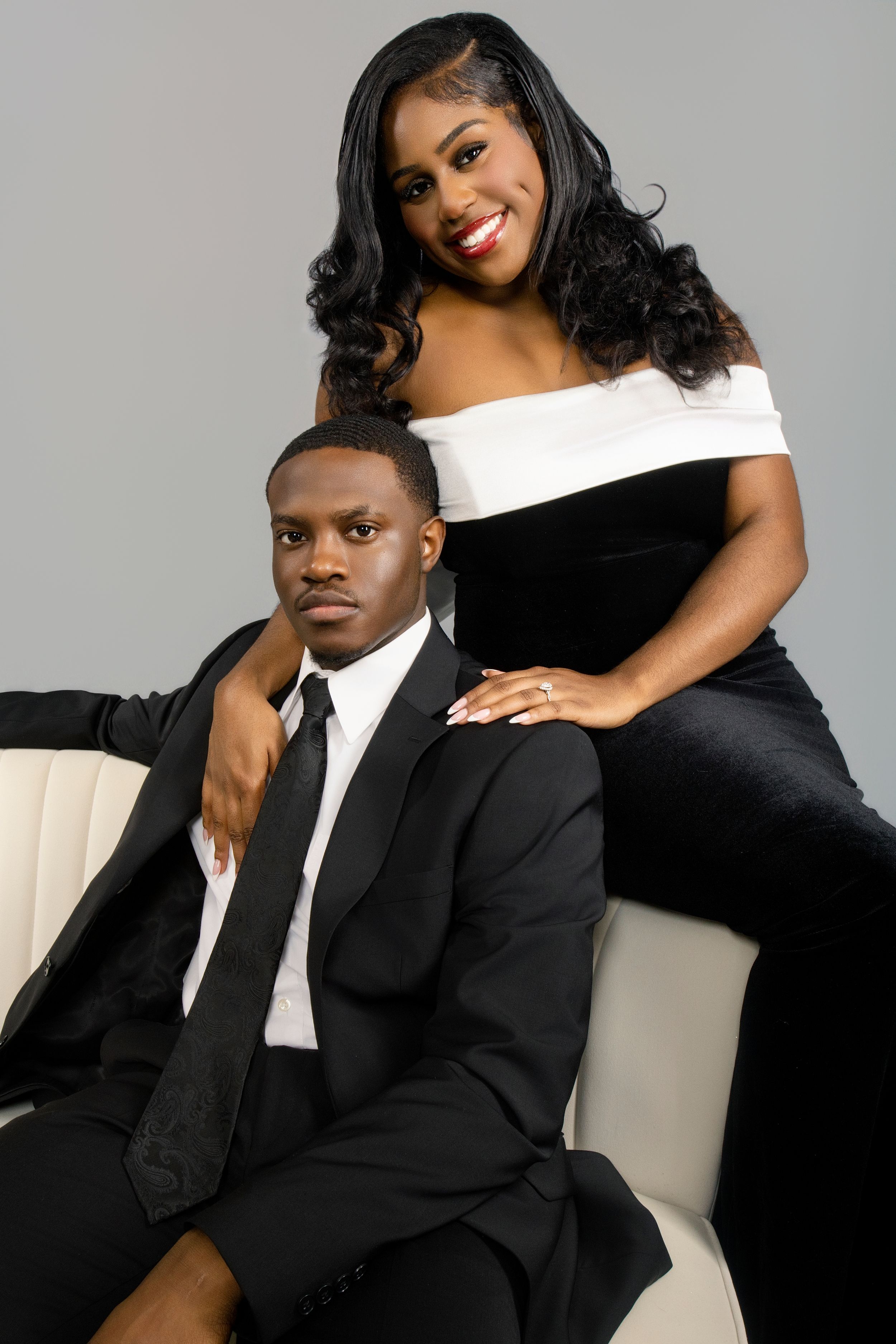 Elegant black and white formal portrait session against grey backdrop.